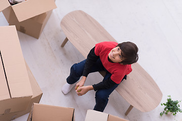 Image showing boy sitting on the table with cardboard boxes around him top vie