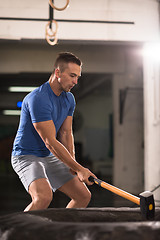 Image showing man workout with hammer and tractor tire