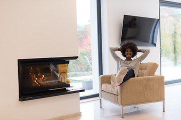 Image showing black woman in front of fireplace