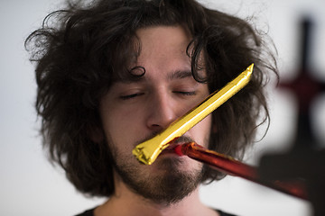 Image showing Portrait of a man in party hat blowing in whistle