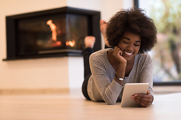 Image showing black women using tablet computer on the floor