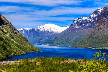 Image showing A beautiful spring day with snow on the mountain peaks, blue sky