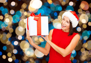 Image showing smiling woman in santa hat with christmas gift