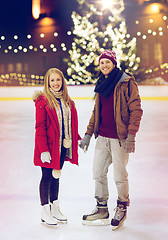 Image showing happy couple holding hands on skating rink