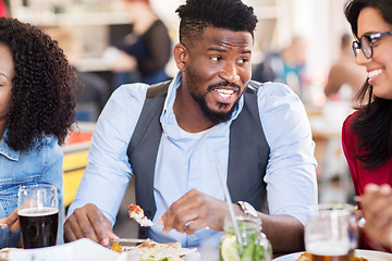 Image showing happy friends eating at restaurant