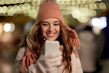 Image showing happy woman with smartphone at christmas