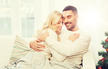 Image showing happy couple hugging on sofa at home