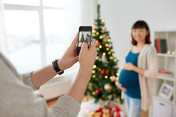 Image showing husband photographing pregnant fife at christmas