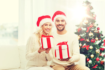 Image showing happy couple at home with christmas gift boxes