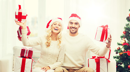 Image showing happy couple at home with christmas gift boxes