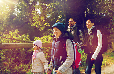 Image showing happy family with backpacks hiking in woods