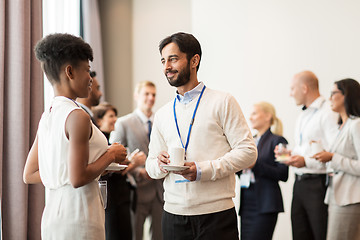 Image showing business people with conference badges and coffee