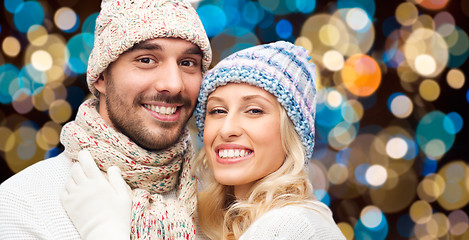 Image showing happy couple in hats over lights background