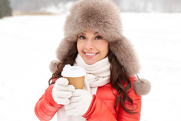 Image showing happy woman in winter fur hat with coffee outdoors