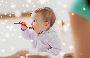 Image showing mother and baby with spoon eating at home