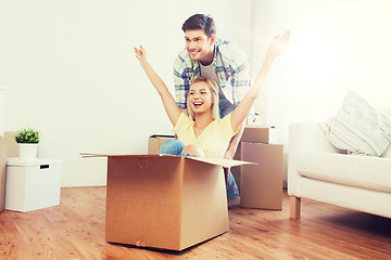 Image showing happy couple having fun with boxes at new home