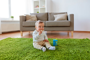 Image showing baby boy on floor and eating rice cracker at home