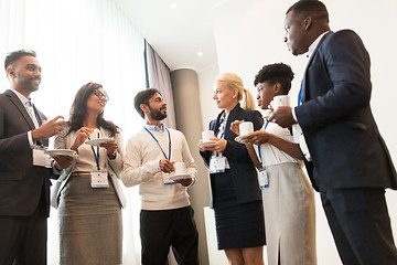 Image showing business people with conference badges and coffee