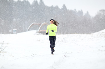 Image showing happy smiling woman running outdoors in winter