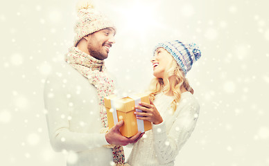 Image showing smiling couple in winter clothes with gift box