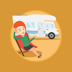 Image showing Woman sitting in chair in front of camper van.