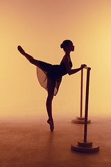 Image showing The young ballerina stretching on the bar