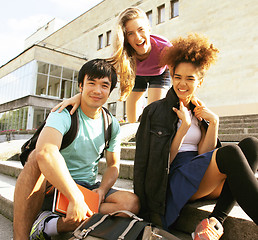 Image showing cute group of teenages at the building of university with books 