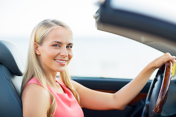 Image showing happy young woman driving convertible car