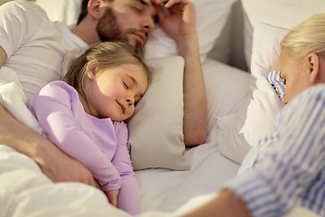 Image showing happy family sleeping in bed at home