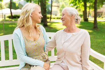 Image showing daughter with senior mother hugging on park bench