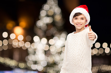 Image showing boy in santa hat showing thumbs up at christmas