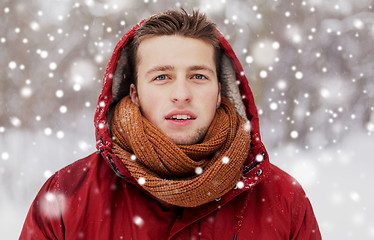 Image showing happy man in winter jacket with hood outdoors