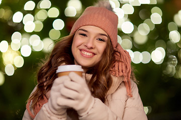 Image showing happy woman with coffee over christmas lights