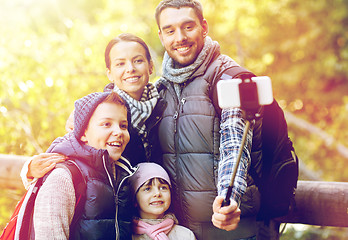 Image showing happy family with smartphone selfie stick in woods