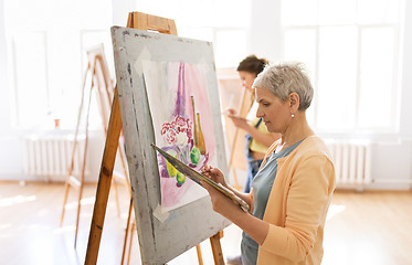 Image showing woman artist with easel painting at art school