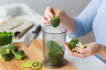 Image showing woman hand adding broccoli to measuring cup