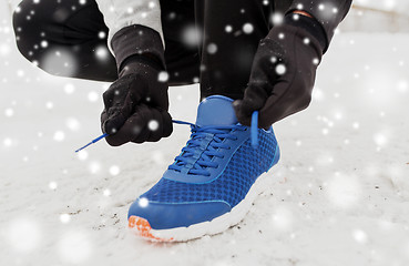 Image showing close up of man tying shoe lace in winter outdoors