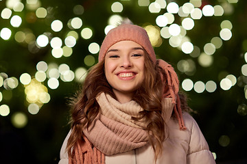 Image showing happy young woman over christmas tree lights