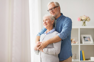 Image showing happy senior couple looking through window at home