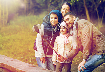 Image showing happy family with smartphone selfie stick at camp