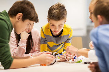 Image showing happy children building robots at robotics school