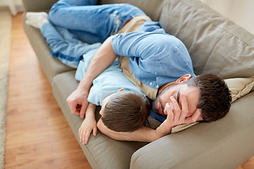 Image showing father and son sleeping on sofa at home