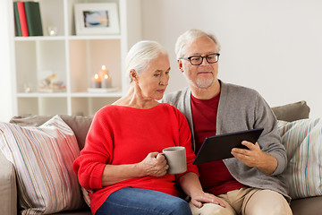 Image showing happy senior couple with tablet pc at christmas