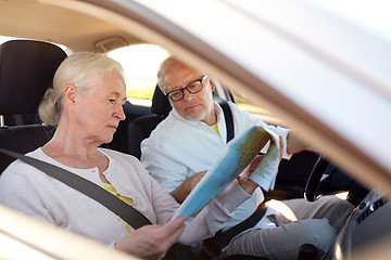 Image showing happy senior couple with map driving in car