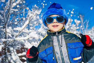 Image showing Happy little boy playing  on winter snow day.