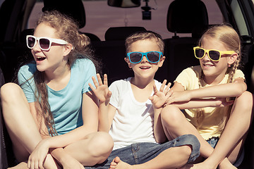 Image showing Happy brother and his two sisters are sitting in the car at the 