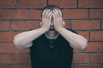 Image showing portrait one sad man standing near a wall