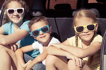 Image showing Happy brother and his two sisters are sitting in the car at the 