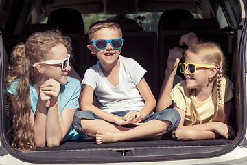 Image showing Happy brother and his two sisters are sitting in the car at the 