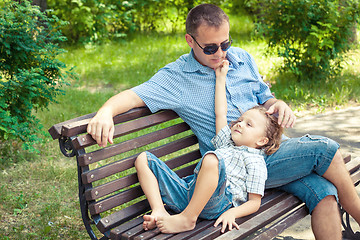 Image showing Father and son playing at the park on bench at the day time.